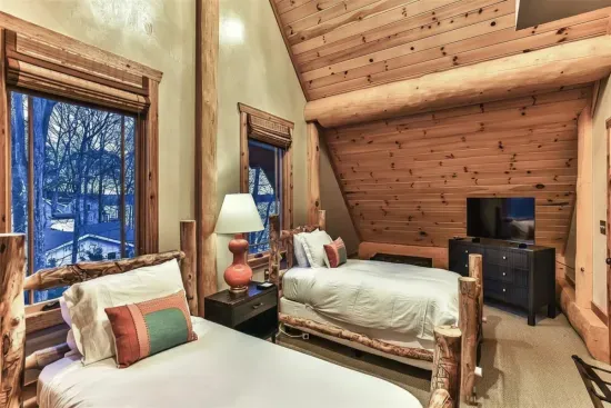 This cozy guest bedroom features two comfortable beds, warm wood finishes, and a peaceful atmosphere—perfect for kids, friends, or additional family members to relax and recharge.