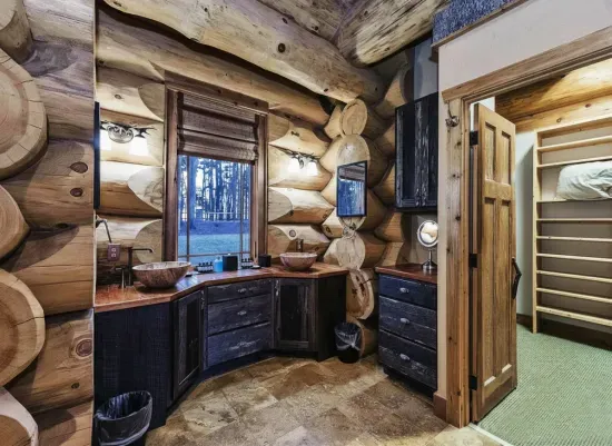Rustic charm meets modern comfort in the primary bath, featuring elegant vessel sinks, stone flooring, and custom cabinetry designed for a relaxing start or end to your day.