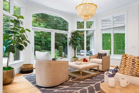 Our sunroom features lots of seating and is surrounded by windows.