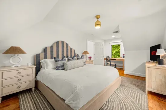 The apartment also features a large king-size bed with TV and the small workspace area.