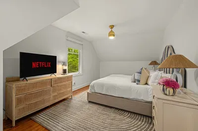 The apartment also features a large king-size bed with TV and the small workspace area.