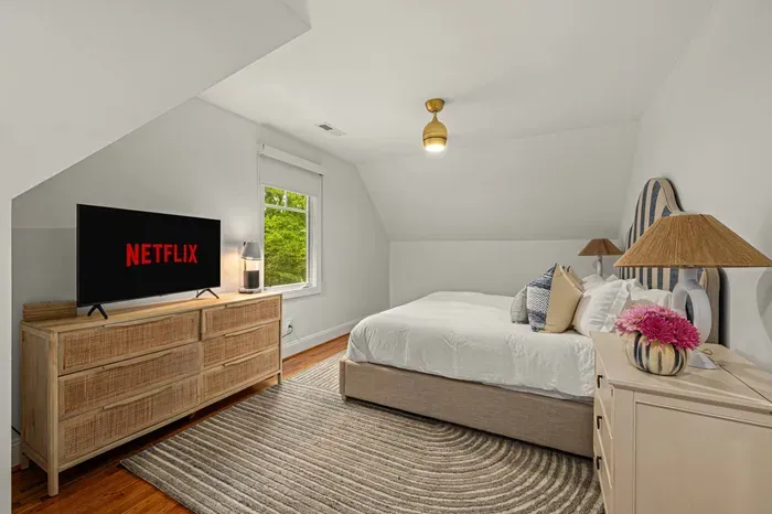 The apartment also features a large king-size bed with TV and the small workspace area.