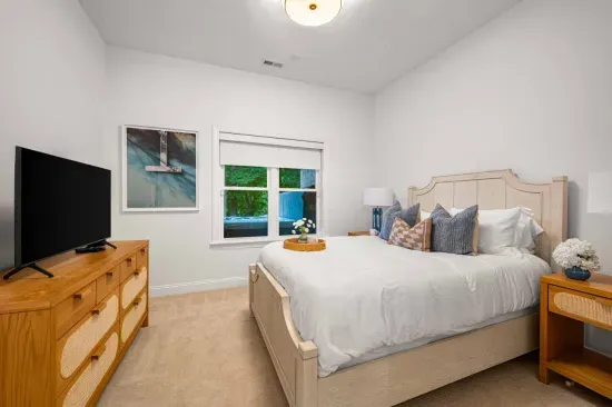 Adjacent to the living room is a well-appointed bedroom with queen bed, TV, and has direct access to a shared bathroom.