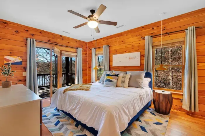 Rest comfortably on our premium king-size mattress in the upstairs primary bedroom with exposed wood walls and lake view.