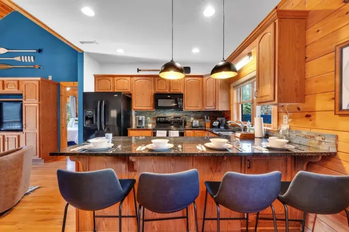 Upstairs kitchen with bar that seats 4 adults for meals.  Kitchen includes non-stick cookware, silverware, plates, glasses, etc. and is ready for cooking!