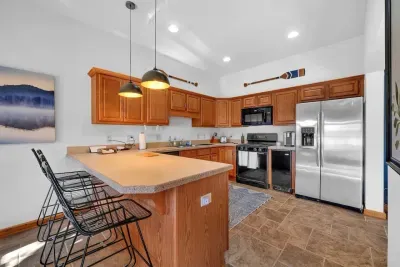 Downstairs kitchen with bar that seats 4 adults for meals.  Kitchen includes non-stick cookware, silverware, plates, glasses, etc. and is ready for cooking!