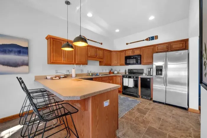 Downstairs kitchen with bar that seats 4 adults for meals.  Kitchen includes non-stick cookware, silverware, plates, glasses, etc. and is ready for cooking!