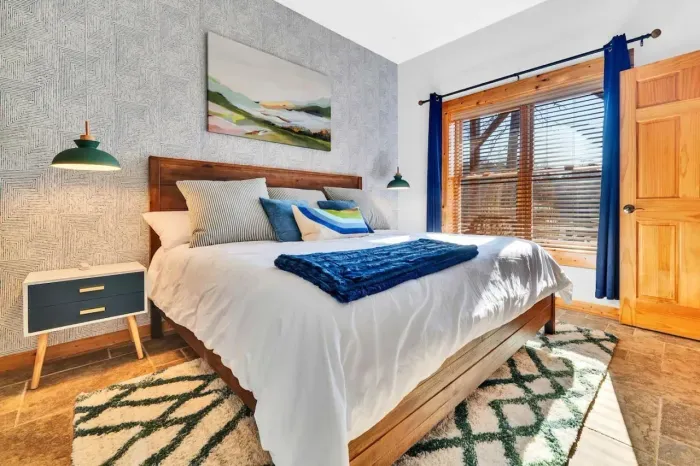 Downstairs primary bedroom with dresser and nightstands.