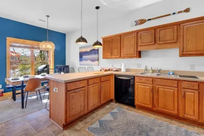 Downstairs kitchen with bar that seats 4 adults for meals.  Kitchen includes non-stick cookware, silverware, plates, glasses, etc. and is ready for cooking!  Dining area is shown in at the back of the photo.