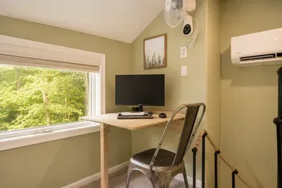 A quiet desk nook pairs
easy focus with a broad,
leafy forest view.