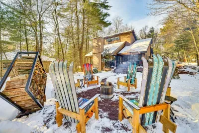Pocono Pines vacation rental near Lake Naomi featuring ski-themed firepit and private wooded backyard at Bearly Roughing It