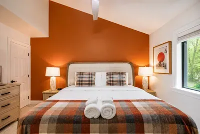 Rust tones, cozy plaid, and
soft linens create a warm
cabin welcome.