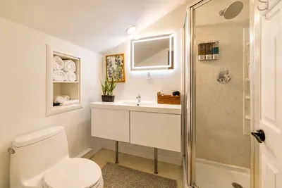 A glowing mirror, walk-in
shower, and rolled towels
create a fresh retreat.
