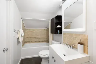 Find our 2nd-floor bathroom off the queen bedroom or staircase. It features a tub with shower, ideal for bathing children. Heads up: Due to unique design, guests over 5 ft tall will need to duck or sit in the shower due to limited height.