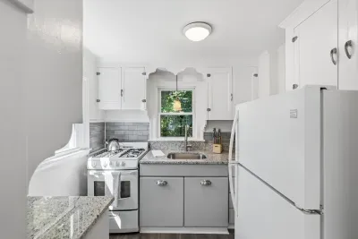 Bright updated kitchen with granite counters and charming window view
