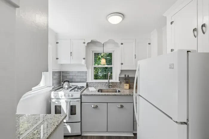 Bright updated kitchen with granite counters and charming window view
