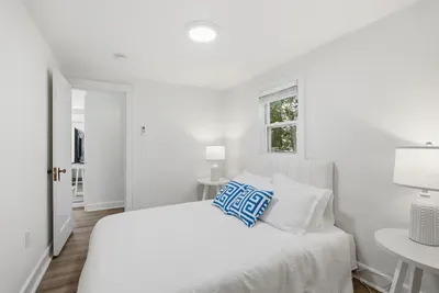 Queen bedroom with plush bedding and natural light, and darkening shades