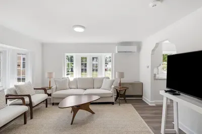 Bright, stylish living room with natural light, TV, and cozy seating