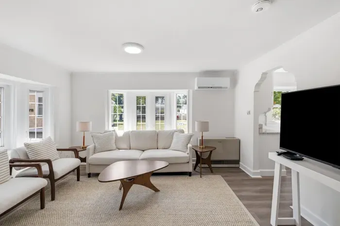 Bright, stylish living room with natural light, TV, and cozy seating