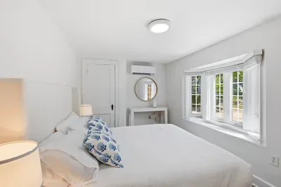 Serene bedroom with bay windows, crisp linens, and a cozy modern feel