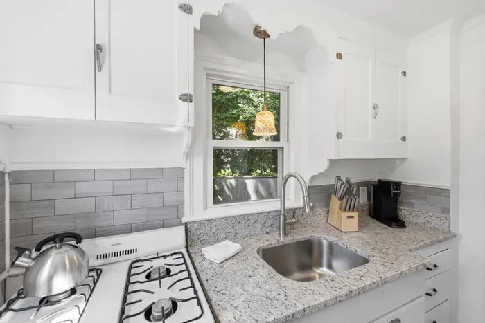 Updated kitchen with granite counters and sunny window views