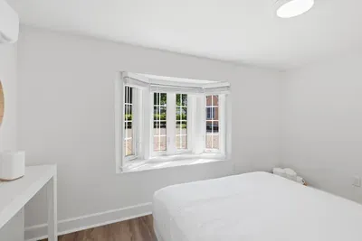 Queen bedroom with sunny bay window with darkening blinds and calming modern style
