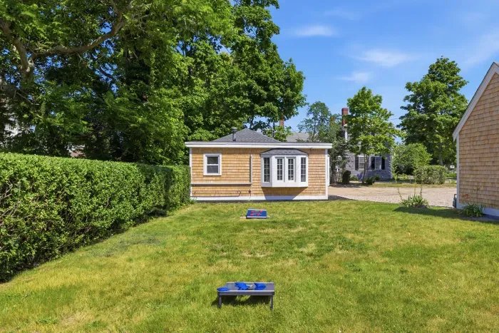 Lawn next to the cottage where guests can play cornhole.