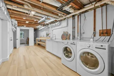 Bright, spacious laundry room with full-size washer/dryer and extra workspace