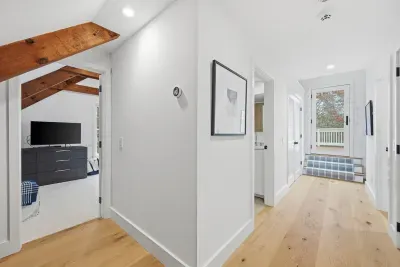 Bright vaulted hallway with wood beams and access to bedrooms and balcony