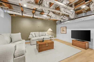 Spacious basement lounge with cozy seating and TV for relaxing nights
