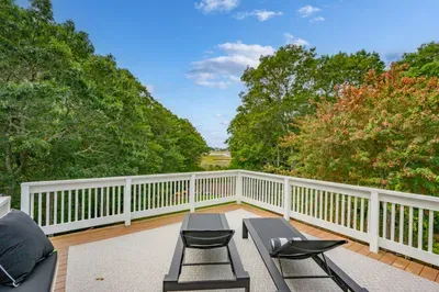 Private treetop deck with lounge seating and peaceful water views