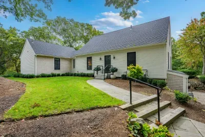 Charming cottage-style home with lush lawn and peaceful wooded setting