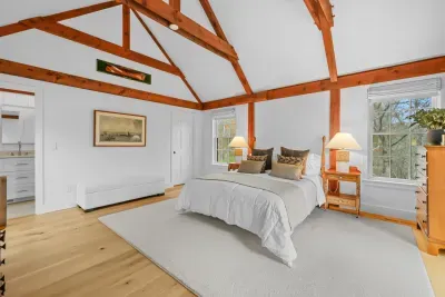 Airy vaulted bedroom with exposed beams and serene natural light