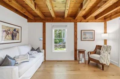 Cozy rustic lounge with exposed beams, natural light, and stylish seating