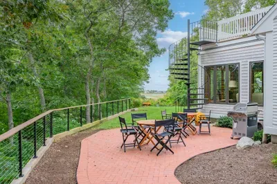 Private tree-lined patio with grill, dining space, and upper deck access