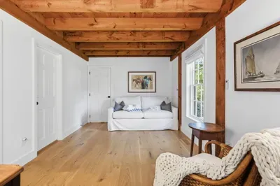 Bright rustic lounge with exposed beams and cozy coastal charm