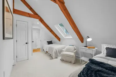 Cozy twin attic room with skylight, exposed beams, and bright airy charm
