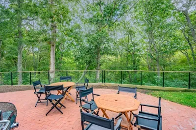 Private wooded patio with outdoor dining and peaceful nature views