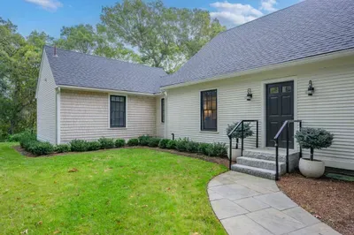 Charming private entry with landscaped lawn and peaceful wooded setting