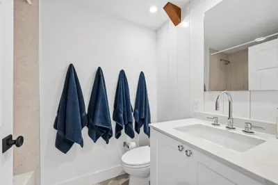 Bright modern bathroom with sleek vanity, large mirror, and spa-like style