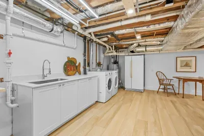 Spacious, bright laundry area with sink, storage and board games