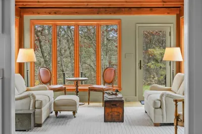 Cozy sunlit lounge with forest views and warm wood accents