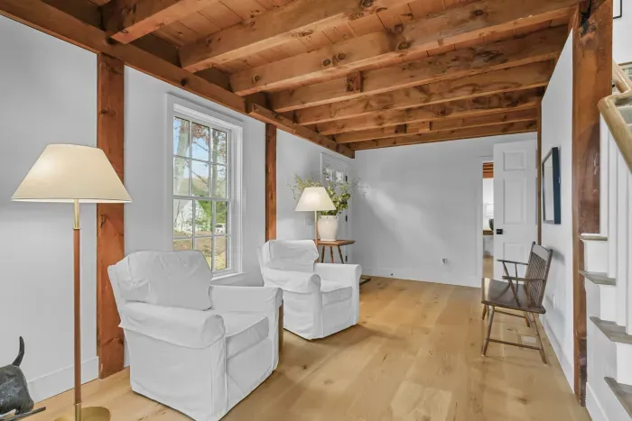 Cozy sitting nook with exposed beams, natural light, and rustic charm