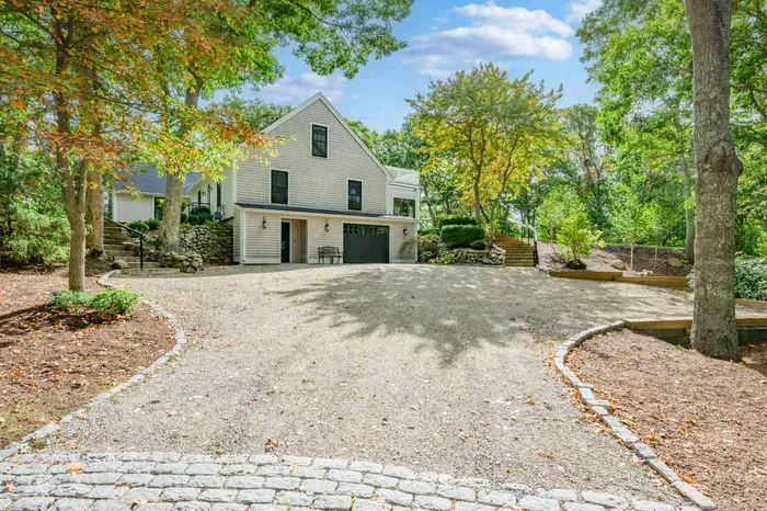 Private wooded retreat with a spacious driveway and charming curb appeal