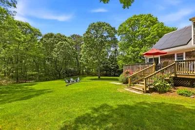 Private backyard oasis with sunny deck, lush lawn, and relaxing seating