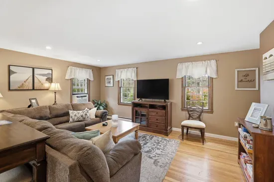 Bright, cozy living room with comfy seating, TV, and warm natural light