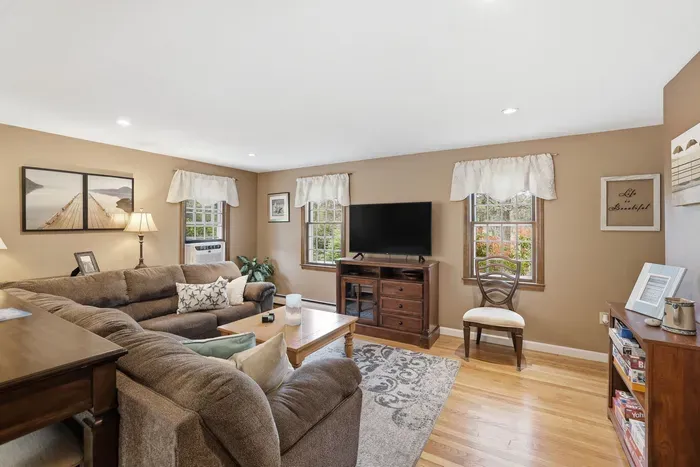 Bright, cozy living room with comfy seating, TV, and warm natural light
