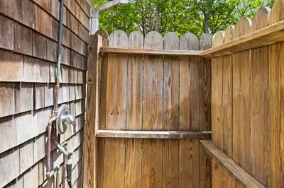 Private outdoor shower with rustic wood fencing and a secluded feel