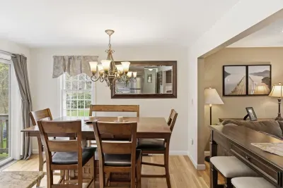 Bright dining space for 6 with chandelier, natural light, and outdoor access