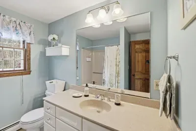 Bright, spacious bathroom with large vanity, natural light, and tub-shower combo